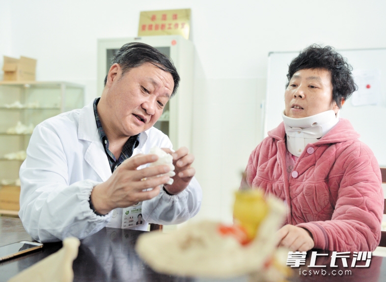雷青拿着模型向患者介绍3D打印技术的优势。 长沙晚报记者 邹麟 摄