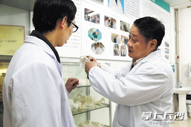 雷青(右)拿着刚打印出来的模型给学生讲解。均为长沙晚报记者 詹春华摄